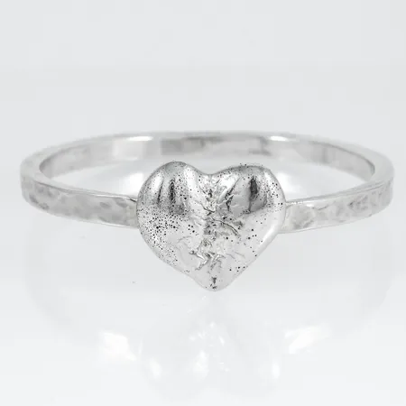 Armring i hamrat silver med dekor i form av hjärta. Innerdiameter 64,5 mm, bredd 5,5 mm, tjocklek 3,9 - 4,7 mm. Hjärta 27 x 24 mm. Stämplad 925. Vikt 60,1g.