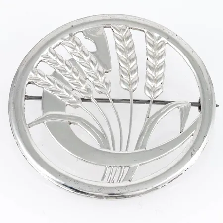 Brosch i silver till Västerbottensdräkten. Ø 47,2 mm. Vikt 10,8g. Tillverkad 1977 av Sporrong.