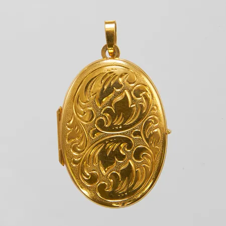 Medaljong med gravyrdekor, 35x21mm, plastinsatser, satinerad baksida, svenska stämplar, liten buckla på baksidan, 18K Vikt: 4,7 g