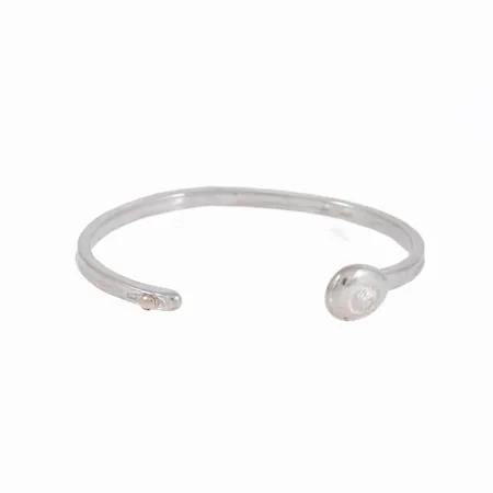 Stelt hamrat armband i silver med liten dekorkula i 18K guld. Innermått 15 cm + 2,8 cm öppning. Bredd 4 - 12 mm. Stämplat 925. Vikt 20,0g.