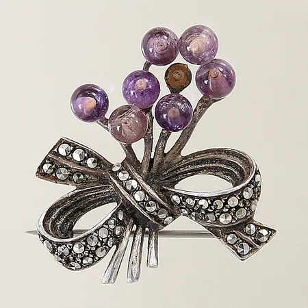 Brosch i from av en rosett samt lila kulor 30x27mm 1 kula saknas silver 830/1000 Vikt: 8,6 g