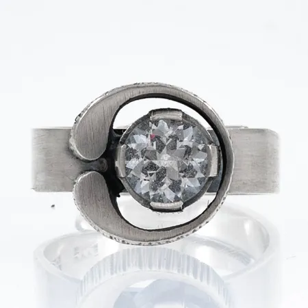 Finnfeelings ring i silver med bergkristall. Ställbar storlek nu ca 17½. Bredd 5 - 12,7 mm. Design Karl Laine. Stämplad 925 X7 (1975) FINLAND och svenska importstämplar. Vikt 5,4g. Originalask i trä/ metall medföljer.