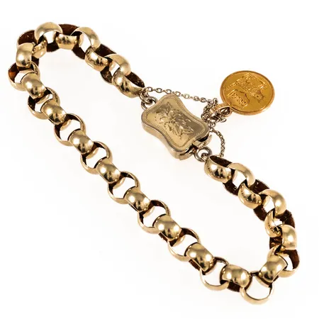 Armband i förgyllt silver med ett vackert graverat kistlås. Längd 21,5 cm. Bredd 7,5 mm. Låset är stämplat AL (Adolf Lilja), Stockholms stadsstämpel, kattfot, B5 (1856). På säkerhetskedjan sitter ett hänge i 18K guld med en graverad katt, monogram och datum 28/2 1863. Totalvikt 11,5g.