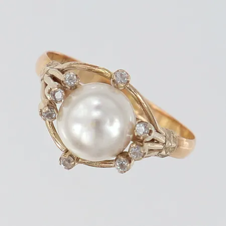 Ring med imitationspärla samt vita stenar stl:19 bredd 2,2-12,5mm 14K. Vikt: 3,1 g