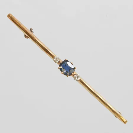 Brosch med en safir ca.5x4mm samt diamanter 2 x ca.0,02ct varav en skadad, Guldvaruaktiebolaget G. Dahlgren & Co Ab, Malmö, 1924, skev broschnål, 18K Vikt: 2,1 g