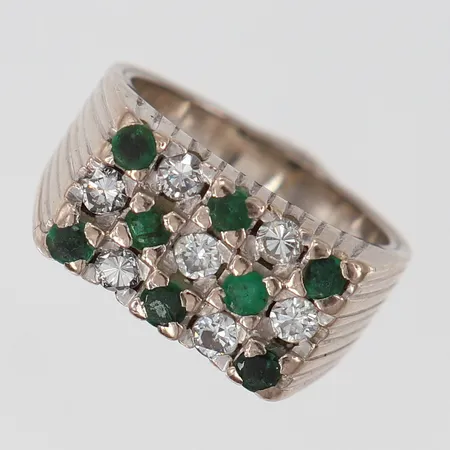 Klackring med troligen smaragder 8 x ca 0,04ct samt diamanter 7 x ca 0,05ct smaragder med slitage/skador stl:16¼ bredd 3,5-9mm behov av om omrodiering vitguld 18K. Vikt: 10,6 g