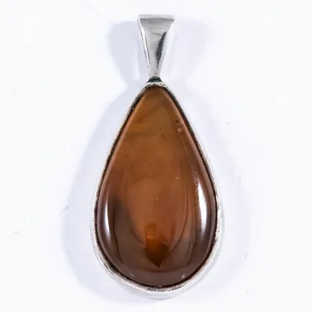 Hänge i silver med en droppslipad orangebrun sten troligen agat. Längd 36,7 mm inkl. fast ögla. Bredd 17,3 mm. Stämplat 925 CK G10 (1981). Vikt 7,0g Vikt: 7 g