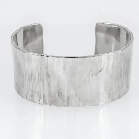 Stelt hamrat armband i silver. Innermått 15,5 cm + 3,5 cm öppning. Bredd 31,5 mm. Stämplat 925. Vikt 88,5g.