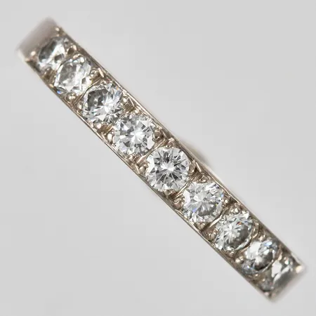 Ring med diamanter ca 9x0,05ct stl: 17 bredd: ca 3mm graverad vitguld 18K Vikt: 3,8 g