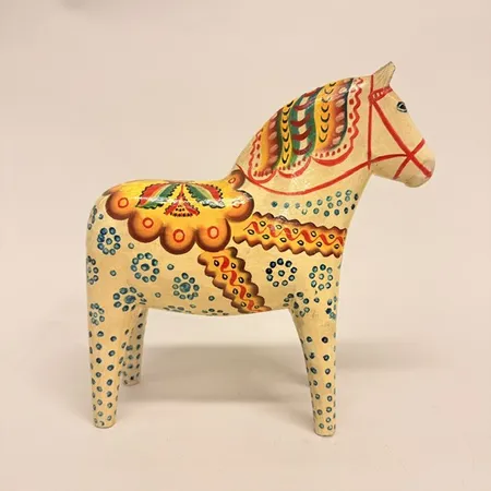 Dalahäst, vit botten med ströpplad dekor i blått, signerad Vattnäs 1961, höjd 24cm, längd 23cm, trä, ytslitage, färgbortfall, avslag på båda öronen, gulnad