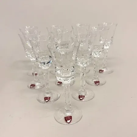 10 likör-/snapsglas, höjd 13cm (2 med mynningsnagg), Linné, etsad dekor, design Olle Alberius, 1979-1983, etikettmärkt Orrefors, Fyrklöverns sigill, kristall Skickas med paket.