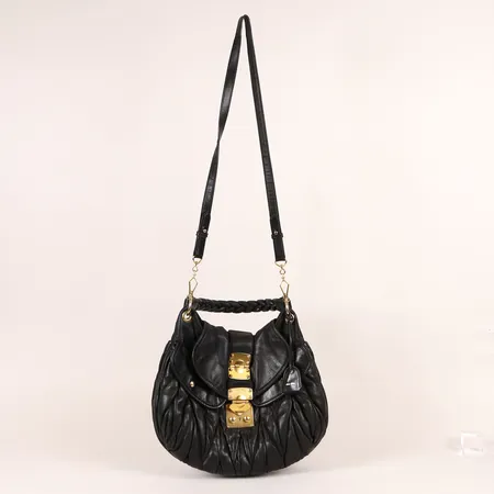 Väska Miu Miu Matelasse Top Handle Bag, svart matlasserat kalvläder med beslag i gulmetall, ca 40x35x11cm, nyckel, ställvis hårt slitage, skada på lock.