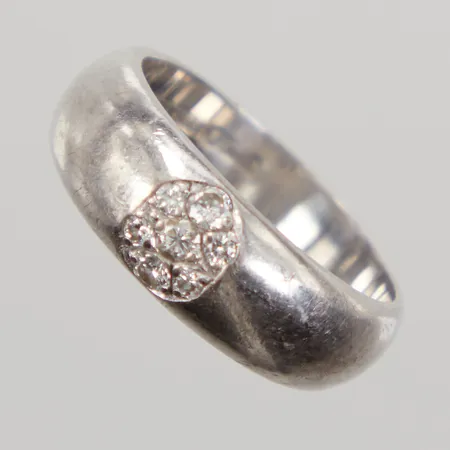 Ring med diamanter 3 x ca 0,03ct samt 2 x ca 0,02ct, stl: 16¾, bredd 6mm, vitguld 18K Vikt: 7 g