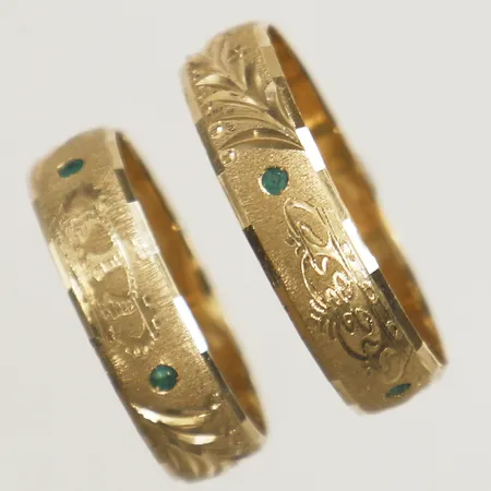 Två ringar med mönsterdekor samt gröna stenar, gravyr 18K Vikt: 7,9 g
