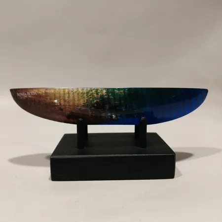 Skulptur Bertil Vallien, Kosta Boda, längd ca 17,5cm flertonat glas med figur invändigt, signerad och numrerad 005821-95 på träsockel.