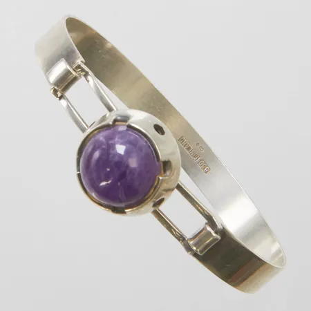 Armring med cabochonslipad ametist, öppningsbar, innerdiameter ca 64mm, bredd 8-9mmm, ametisten ca Ø13,5mm, finska stämplar, 830/1000 silver Vikt: 21,1g Vikt: 21,1 g