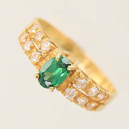 Ring med vita stenar samt en grön sten stl:17½ bredd:2-6mm, något skev skena, 18K  Vikt: 2,7 g
