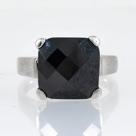 Ring i silver med en checkerboardslipad svart sten. Stl:18. Bredd 2,5 -12,2 mm. Guldfynd. Vikt 6,5g 925/1000.