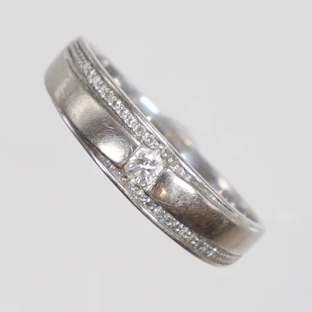 Ring i vitguld med diamanter 1xca0,06ct samt 22xca0,005ct stl:18 bredd 2-5mm GHA 18K Vikt: 3 g