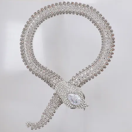 Collier längd 63cm, bredd 10-35mm, innermått ca 36cm, orm med vita stenar, vitmetall, smycka, en sten lös, box Skickas med postpaket.
