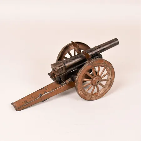 Leksakskanon, bemålad plåt, 1900-talets första hälft, höjd 10,5cm, bruks- och åldersbetingat slitage.