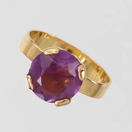 Ring med lila sten stl ca 16½ bredd 4-10mm, skev 18K Vikt: 3,3 g