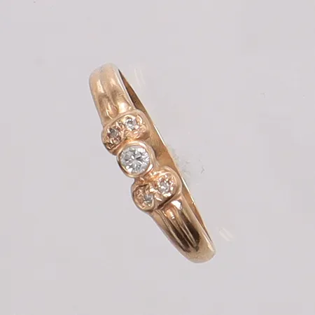 Ring med diamanter 1 x ca 0,05ct + 4 x ca 0,005ct stl:18, bredd ca 1,6-4,5mm, något skev, 14K Vikt: 1,7 g