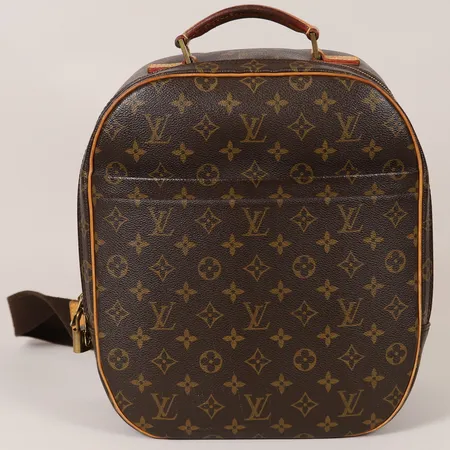Ryggsäck Louis Vuitton Sac à Dos Packall Sling, brun monogramcanvas, beslag i gulmetall samt ljusa läderdetaljer, axelrem i tyg, mått ca 32x12,5x29cm, datumkod: BA0090 för år 2000 Frankrike, bruksslitage, mindre fläckar invändigt samt utvändigt, tillhörande lås med nycklar, dustbag, inga övriga tillbehör. 