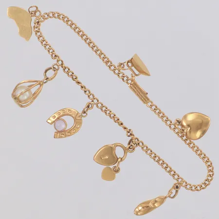 Armband med 7 berlocker längd 17cm, några berlocker buckliga, 18K Vikt: 8 g