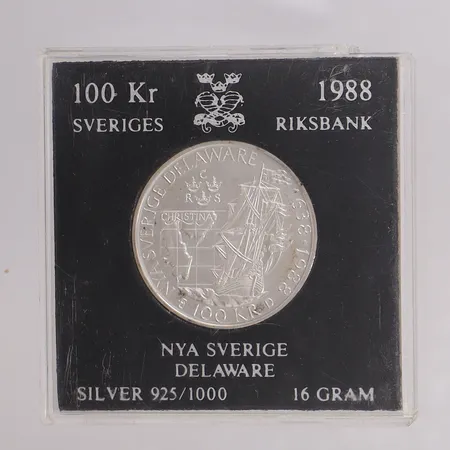 Minnesmynt 100kr Nya Sverige Delaware år 1988, Ø32mm, trasigt plastetui, 925/1000 silver Vikt: 16 g