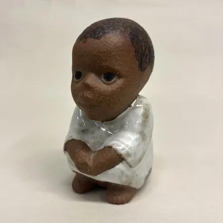 Figurin Syd, ur serien All världens barn, formgivare Lisa Larson, Gustavsberg, höjd 10,5cm, stengods, etikett, stämpelmärkt, krackeleringar