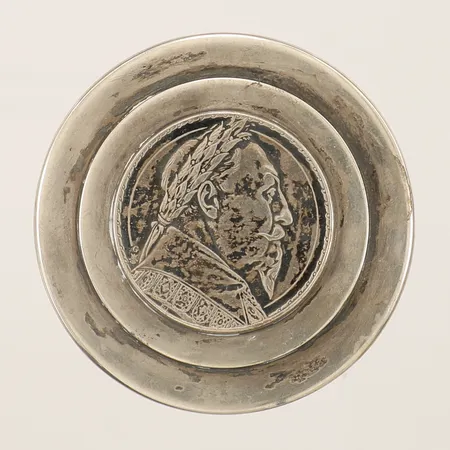 Burk med lock med dekor av mynt Trehundraårs minne av Konung Gustaf II Adolfs död vid Lützen 6 nov 1632 år 1932 Ø54mm höjd 31mm A. Laurén&S 1938 silver 830/1000 Vikt: 67,4 g