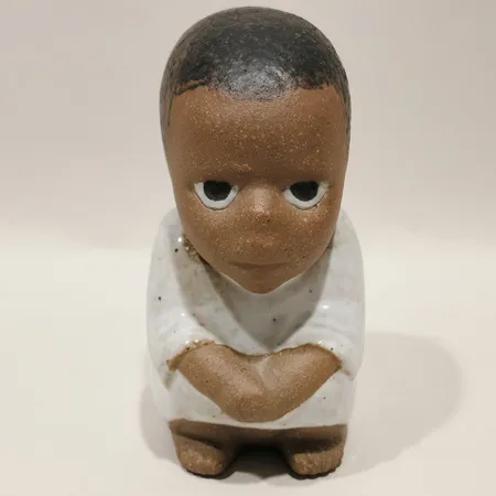 Figurin Syd ur serien "Alla världens barn" av Lisa Larson, Gustavsberg Höjd 10cm, svag krackelering i i glasyren.