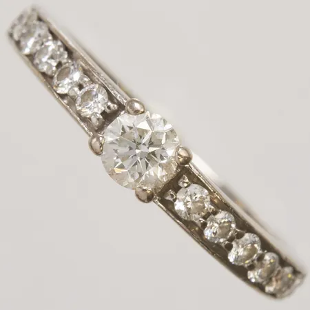Ring med diamanter 1x0,25ct, 12xca 0,02ct, stl:15½, bredd 2,5-4mm, enligt uppgift från Hallbergs SI, Wesselton, dokumentation medföljer, inga övriga tillbehör, 18K Vikt: 3,6g Vikt: 3,6 g