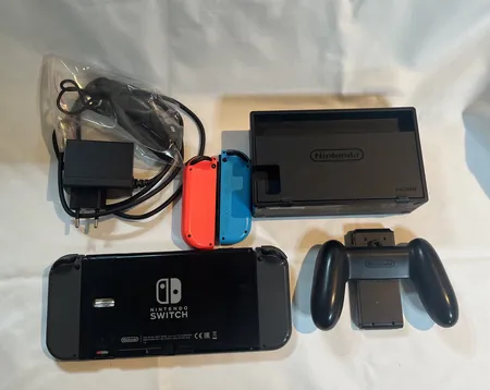 Nintendo Switch OLED, modell HEG-001, Joy-Con-par, Joy-Con-grepp, strömkabel, dockstation, Joy-Con-remmar, manual, extra handkontroll. Vikt: 0 g Skickas med postpaket.