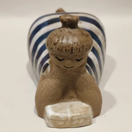 Figurin Beata Lisa Larson för Gustavsberg ur serien ABC-flickorna höjd ca 9cm längd ca 19cm stämpelmärkt signerad bemålad och glaserad stengods små krackeleringar och glasyrskador.