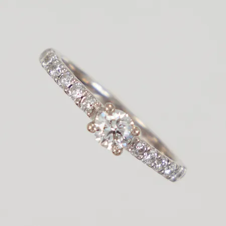 Ring med syntetiska diamanter 1x ca 0,25ct + 12x 0,02ct, stl 16¾, bredd 2-4,3mm, GOFS vitguld 18K Vikt: 2,7 g
