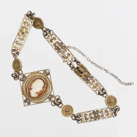 Armband med snidad snäckskalskamé samt filigranarbete, en ögla skadad, längd 19cm, bredd 6 - 25mm, säkerhetskedja defekt/av, svenska importstämplar, silver 830/1000 Vikt: 9 g