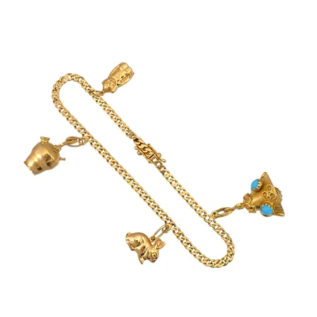 Armband Pansar med fyra berlocker i 18K guld, tillverkarstämpel SGT, svensk kontrollstämpel, turkosa stenar, armbandets längd knäppt 19,0 cm, bredd 3 mm, berlocker med varierande mått, en berlock (kannan) saknar en sten och har ojämnheter, för övrigt i fint skick Vikt: 12,6 g