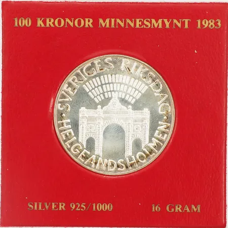 Minnesmynt 100kr Sveriges Riksdag Helgeandsholmen år 1983 Ø32mm defekt plastetui silver 925/1000 Vikt: 15,7 g