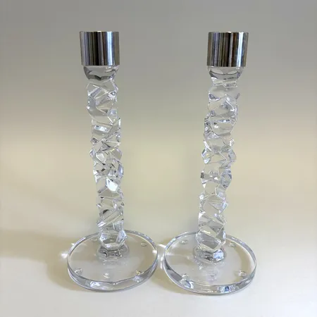 Ljusstakar ett par "Carat" Orrefors formgivna av Lena Bergström ljushållare i rostfritt, höjd 23,5 cm fotplatta Ø9,5 cm båda ljusstakarna märkta i botten samt med etikett.