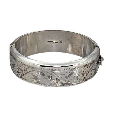 Armring 1950-tal, silver, Atelje Waldemar Jonsson Skara, märkt HANDARBETE Waldemar SKARA SWEDEN, oval modell, öppningsbar, graverad dekor på ena halvan, inre mått 17 cm, bredd 21 mm, tillverkad 1957 Vikt: 48,1 g