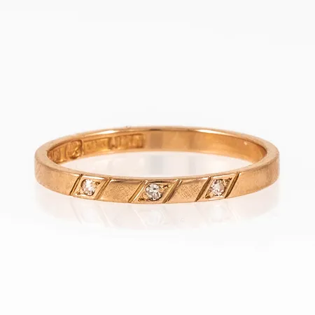Ring i 18K guld med 3 x 0,01ct 8/8 slipade diamanter. Den är i storlek 17½, är 2 mm bred och väger 1,9g. Stenstorlek 0,03ct ingraverat. Stämplad I10 (1983), GD&Co (Guldvaruaktiebolaget G. Dahlgren & Co AB Malmö), 18K, kattfot. 