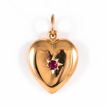 Hänge Hjärta i 18K guld med röd sten. Det är 12 mm brett, 18,5 mm långt inkl. ögla och väger 0,9g. 