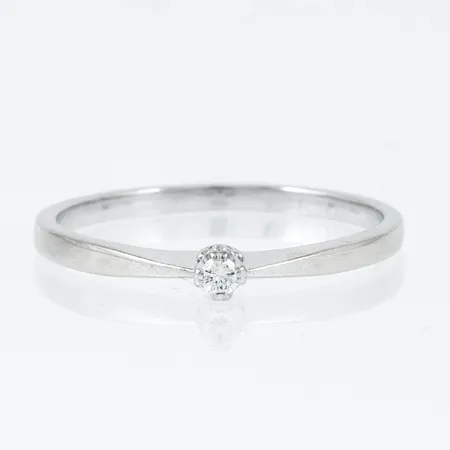 Ring i 18K vitguld med 1 x c:a 0,03ct briljantslipad diamant. Den är i storlek 20, är 1,7 - 3 mm bred och väger 2,5g. Stämplad GHA (Guldfynd)
