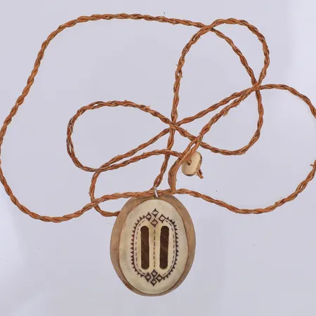 Hänge i horn & trä med samiskt mönster 40mm långt, ingen signatur, tvinnat läderband ca 72cm