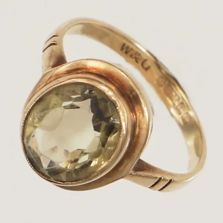 Ring med gul sten, stl 15¾, bredd 12,5mm, gravyr, England, 9K Vikt: 2,4 g