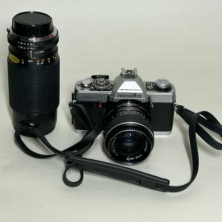 Kamera Minolta XG2 analog med plastrem med objektiv Tokina 35mm f 2,8 & Objektiv Tokina 80-200mm f 4,0 i egen väska medföljande blixt Nissin 24ASO auto, hård kameraväska Skickas med postpaket.
