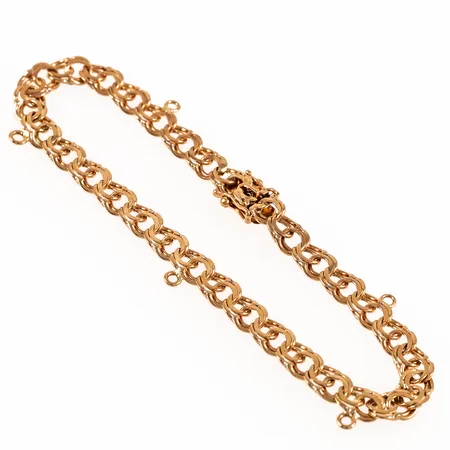 Armband Bismarck i 18K guld. Det är 17,5 cm långt, 5 mm brett och väger 7,0g. Kistlås. Fem pålödda öglor för berlocker. Stämplad 18K och kattfot. 