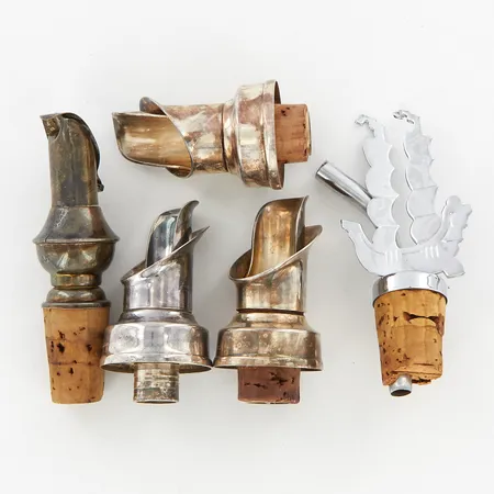 4 vinkorkar i nysilver, en vinkork i metall, en saknar kork, sprickor.  Vikt: 0 g